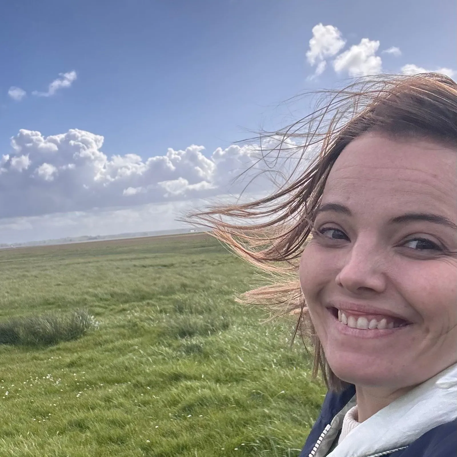 un coucou de Marie devant un champ entrain d'être labouré par un tracteur